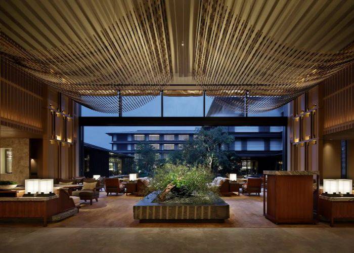 The stunning lobby of the Hotel Mitsui Kyoto, featuring plants and comfy seating areas.